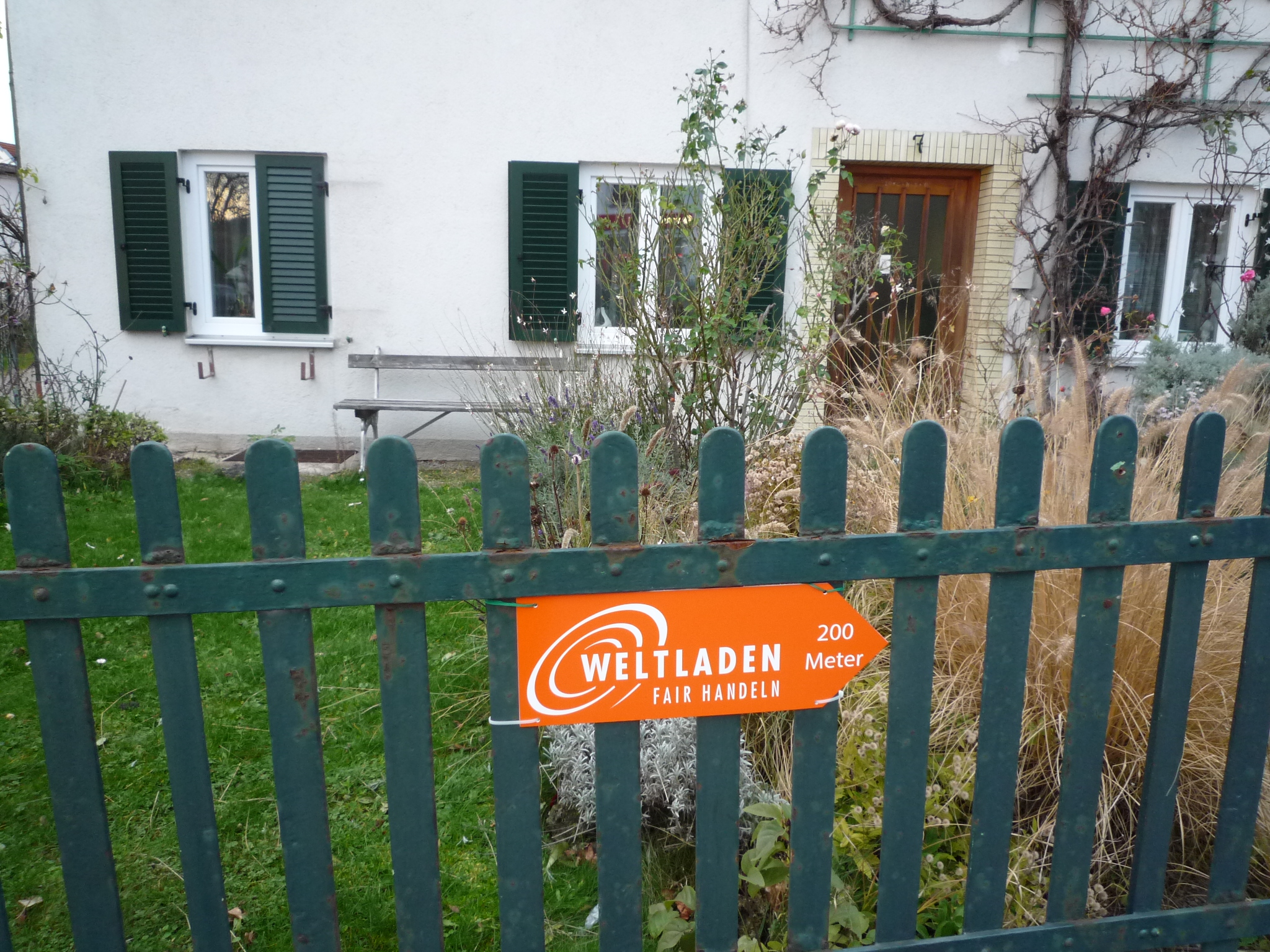Weltladen-Schild an Gartenzaun